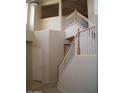 Staircase with wooden handrail, white spindles, and neutral colored walls at 1794 N Agave St, Casa Grande, AZ 85122
