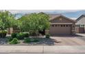 Charming exterior featuring a two-car garage, well-manicured trees and landscaped yard at 18731 W San Juan Ave, Litchfield Park, AZ 85340
