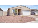 Inviting home with a brick driveway, neutral stucco, a white garage door, and desert landscaping at 24610 W Bowker St, Buckeye, AZ 85326