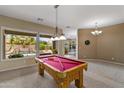 Spacious game room featuring a pool table and large windows overlooking the pool at 2612 S Jacob St, Gilbert, AZ 85295