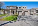Elegant two-story house with stone accents, three-car garage, and well-maintained lawn, displaying curb appeal at 2988 E Comstock Dr, Gilbert, AZ 85296