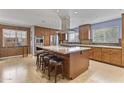 Spacious kitchen featuring wooden cabinets, a granite island with seating, and modern stainless steel appliances at 3002 E Montecito Ave, Phoenix, AZ 85016