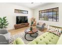 Inviting living room with wood-look floors, large windows, modern furniture, and neutral colors at 3115 N 34Th Pl, Phoenix, AZ 85018