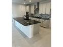 Contemporary kitchen featuring a large island with granite countertop, stainless steel appliances and white cabinets at 31274 N 130Th Ave, Peoria, AZ 85383
