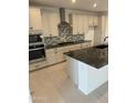 Modern kitchen showcasing stainless steel appliances, speckled black granite counters, and white cabinets at 31274 N 130Th Ave, Peoria, AZ 85383