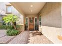 Inviting front porch with stone tile, desert landscaping, and a solid wood front door at 3648 E Fargo St, Mesa, AZ 85205