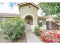 Charming covered entry with an arched doorway, wreath, and lush landscaping at 4110 E Brighton Way, San Tan Valley, AZ 85140