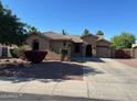 Charming single-story home with a well-maintained yard, a spacious driveway, and a sidewalk at 4130 E Megan St, Gilbert, AZ 85295