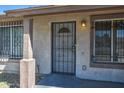 Close-up of the front door area, with security bars and weathered features, needs some renovation at 4870 W Almeria Rd, Phoenix, AZ 85035