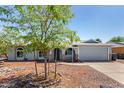 Well-maintained single-story home featuring desert landscaping, light blue exterior paint, and a two-car garage at 4915 W Libby St, Glendale, AZ 85308