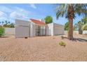 Cozy single-story home featuring a white exterior, tile roof, and low maintenance gravel landscaping at 511 E Calavar Rd, Phoenix, AZ 85022