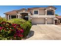 Stately two-story home with a three-car garage, balcony, and mature landscaping at 5322 N Oro Vista Ct, Litchfield Park, AZ 85340