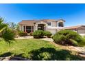 Attractive home featuring a well-kept lawn, colorful flowers, and desert-friendly landscaping at 5322 N Oro Vista Ct, Litchfield Park, AZ 85340