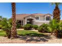 Beautiful home with palm trees, lush bushes, and a well-manicured lawn at 5322 N Oro Vista Ct, Litchfield Park, AZ 85340