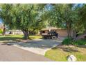 Long driveway leading to a brick ranch home with mature trees offering privacy and shade at 6637 W Pershing Ave, Glendale, AZ 85304