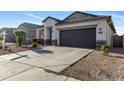 Wide driveway leads to a two-car garage of a modern home with desert landscaping at 7812 W Payson Rd, Phoenix, AZ 85043