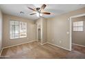 Neutral bedroom features a ceiling fan, a large window, and a sliding door closet at 9233 E Neville Ave # 1125, Mesa, AZ 85209