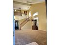 Open living room space with tall ceilings, staircase and natural light at 11867 W Alvarado Rd, Avondale, AZ 85392