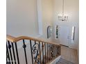 Bright foyer with iron railing staircase, pendant lighting, and views of the front door and exterior at 1187 E Frances Ln, Gilbert, AZ 85295