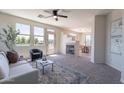 Inviting living room featuring a fireplace, large windows, and neutral decor with an adjacent dining area at 1187 E Frances Ln, Gilbert, AZ 85295