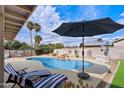 Inviting backyard pool area with lounge chairs, rock waterfall feature, and ample patio space at 13411 N 50Th St, Scottsdale, AZ 85254