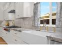 Bright kitchen featuring a farmhouse sink, granite countertops, and stainless steel appliances at 13914 E Laurel Ln, Scottsdale, AZ 85259