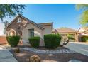 Charming home featuring a stone facade, manicured bushes, and a well-maintained yard at 15272 W Georgia Dr, Surprise, AZ 85379