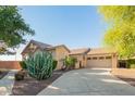 Beautiful single-story home with desert landscaping, a three-car garage, and a paver driveway at 15272 W Georgia Dr, Surprise, AZ 85379