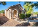 Charming covered front porch with stone facade and manicured bushes at 15272 W Georgia Dr, Surprise, AZ 85379