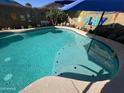 Refreshing pool with a tanning ledge, framed by tropical decor and a playful backdrop for outdoor enjoyment at 15939 W Post Dr, Surprise, AZ 85374