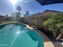 Beautiful pool area surrounded by lush landscaping, offering a serene escape in this private backyard retreat at 15939 W Post Dr, Surprise, AZ 85374