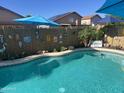 Backyard oasis featuring a sparkling pool, tropical plants, and a decorative bamboo fence for ultimate privacy and enjoyment at 15939 W Post Dr, Surprise, AZ 85374