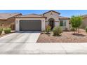 Inviting single-story home with a gray garage door, arched entry, tiled roof, and a low-maintenance landscaped front yard at 19627 W Badgett Ln, Litchfield Park, AZ 85340