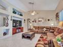 Spacious living room with a leather sectional, media center, neutral walls, and tile floors at 230 S 122Nd Ln, Avondale, AZ 85323