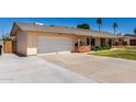 Spacious home featuring an attached garage, green lawn, and front porch at 2330 E Elmwood St, Mesa, AZ 85213