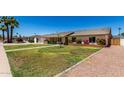 Street view of single-story home with manicured lawn, landscaping and driveway at 2330 E Elmwood St, Mesa, AZ 85213