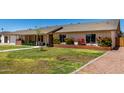 View of front yard of single-story home showing lawn, sidewalk, and brick planters at 2330 E Elmwood St, Mesa, AZ 85213