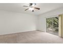 Bright bedroom features neutral carpet, ceiling fan, and sliding door access to the outdoors at 39016 N Habitat Cir, Cave Creek, AZ 85331