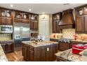 Gourmet kitchen featuring custom wood cabinetry, an island, and stainless steel appliances at 5512 E Barwick Dr, Cave Creek, AZ 85331