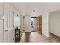 Inviting foyer showcasing wood-look floors and decorative wood front door at 6 E Piping Rock Rd, Phoenix, AZ 85022