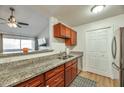 Galley kitchen showcases granite countertops and wooden cabinets; a breakfast bar connects it to the open-concept living space at 623 W Guadalupe Rd # 213, Mesa, AZ 85210
