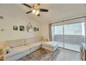 Bright living room features a large sectional couch and sliding doors to a private balcony with outdoor space at 623 W Guadalupe Rd # 213, Mesa, AZ 85210