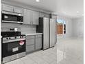 Modern kitchen with stainless steel appliances, gray cabinets, and a bright, airy feel at 6332 W Sunnyslope Ln, Glendale, AZ 85302