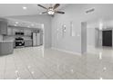 Open-concept living room with modern tile flooring, ceiling fan, and easy access to the kitchen at 6332 W Sunnyslope Ln, Glendale, AZ 85302