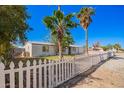 Attractive single-story home with a white picket fence and mature shade trees in a well-maintained yard at 7011 W Carol Ann Way, Peoria, AZ 85382
