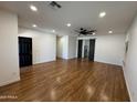 Spacious living room with wood floors, modern lighting, barn door, and neutral walls at 7111 S 21St Dr, Phoenix, AZ 85041