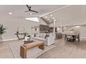 Open-concept living room featuring a fireplace, high ceilings, and seamless flow into the dining area at 7962 E San Miguel Ave, Scottsdale, AZ 85250