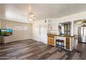 Open living area showcasing wood flooring, a ceiling fan, and a view into the updated kitchen at 8042 N 28Th Ave, Phoenix, AZ 85051