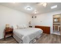 Bright main bedroom featuring wood floors, neutral tones, a ceiling fan, and ensuite bathroom at 8042 N 28Th Ave, Phoenix, AZ 85051