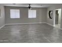 Bright living room featuring tile flooring and a contemporary ceiling fan at 845 N Los Alamos Dr, Goodyear, AZ 85338
